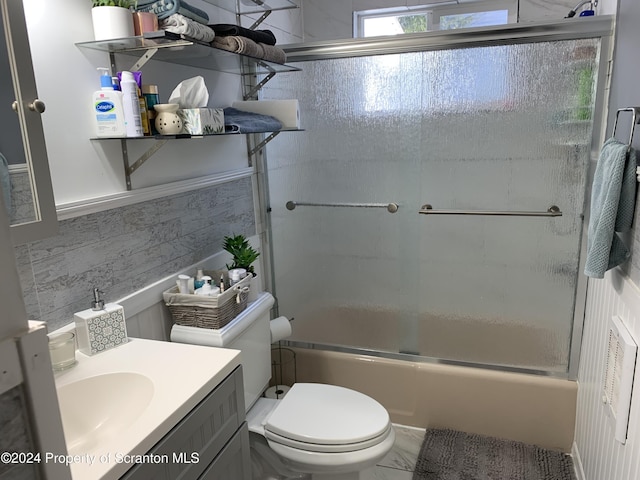 full bathroom with vanity, enclosed tub / shower combo, and toilet