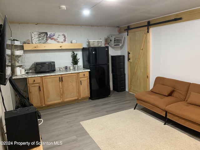 living room featuring a barn door and light hardwood / wood-style flooring