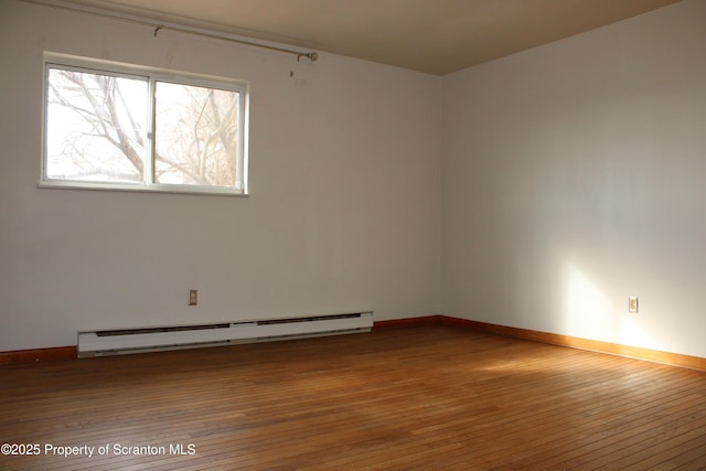 spare room with a baseboard radiator and hardwood / wood-style flooring