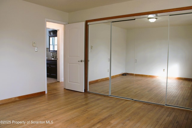 unfurnished bedroom featuring a closet and light hardwood / wood-style flooring