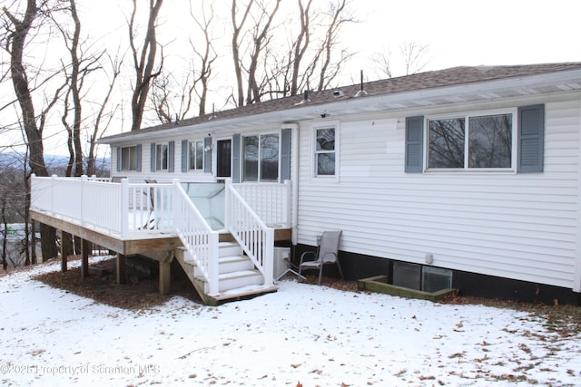 snow covered property featuring a wooden deck