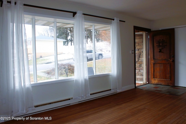 doorway to outside featuring baseboard heating and dark wood-type flooring