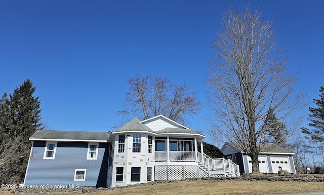 view of front facade featuring an outbuilding, a sunroom, and a detached garage