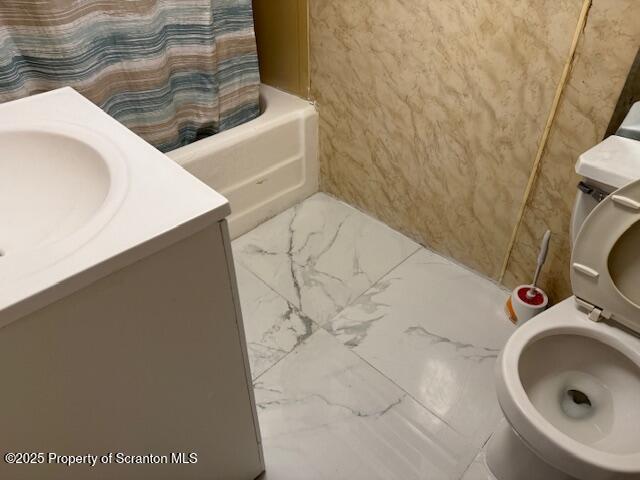 bathroom featuring toilet, marble finish floor, and vanity