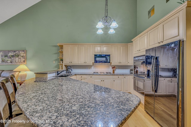 33 Hedge Row Run, Clarks Summit, PA 18411 - kitchen with a towering ceiling, a peninsula, black appliances, a chandelier, and light wood-type flooring