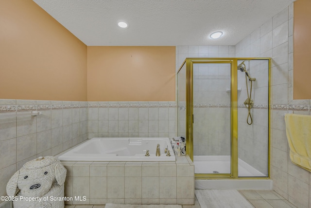 33 Hedge Row Run, Clarks Summit, PA 18411 - full bathroom with a textured ceiling, a garden tub, a shower stall, tile walls, and recessed lighting