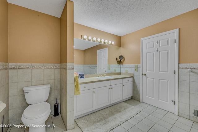 33 Hedge Row Run, Clarks Summit, PA 18411 - bathroom with tile walls, vanity, a wainscoted wall, tile patterned floors, and a textured ceiling