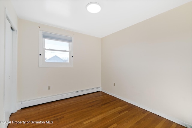 unfurnished room with hardwood / wood-style floors and a baseboard radiator