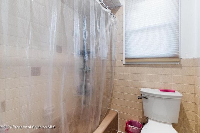 bathroom featuring shower / bath combination with curtain and toilet