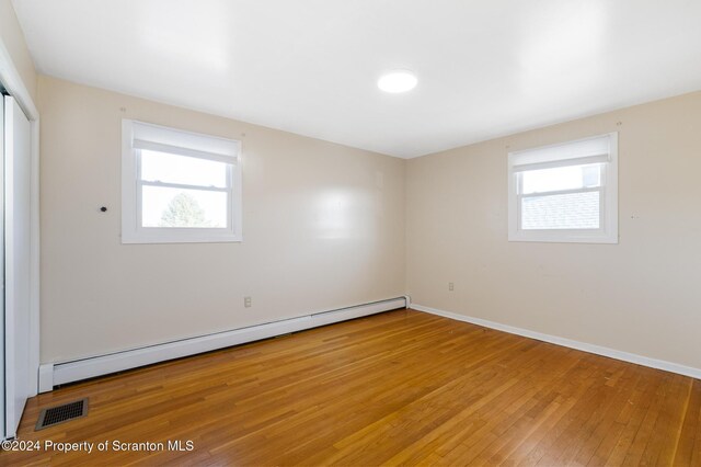 spare room with hardwood / wood-style floors and a baseboard radiator