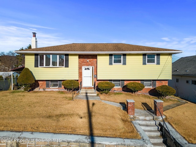 bi-level home with a front lawn