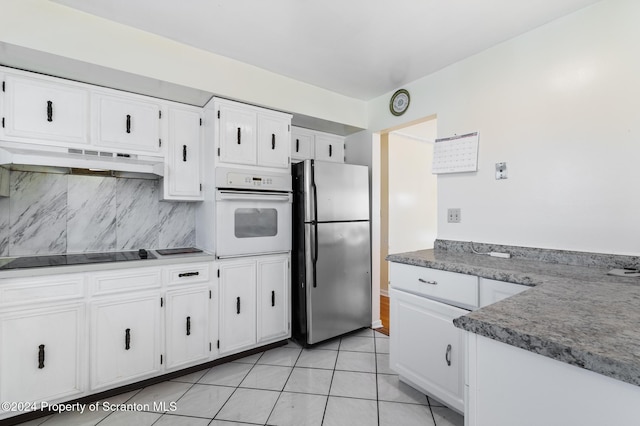 kitchen featuring white oven, stainless steel fridge, black electric stovetop, white cabinets, and custom range hood