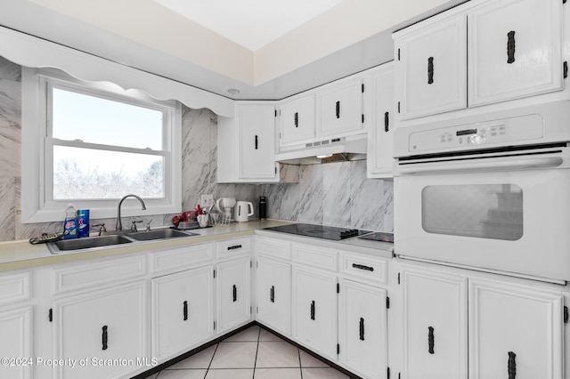 kitchen with white cabinetry, sink, oven, black electric stovetop, and custom range hood