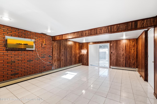 spare room with wood walls, light tile patterned flooring, and a baseboard heating unit