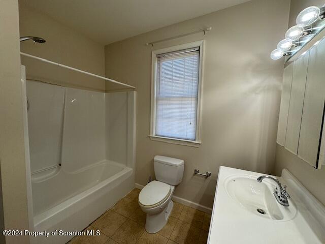 full bathroom with tile patterned floors, vanity, toilet, and a wealth of natural light