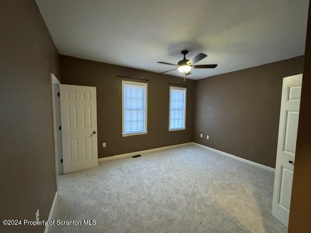 unfurnished bedroom with ceiling fan and light carpet