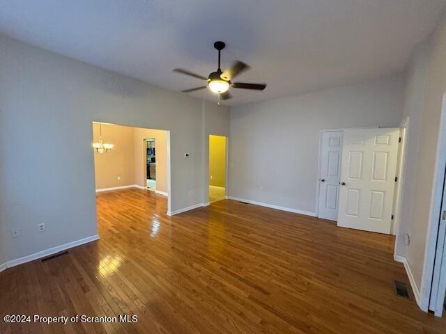 interior space featuring dark hardwood / wood-style floors and ceiling fan with notable chandelier