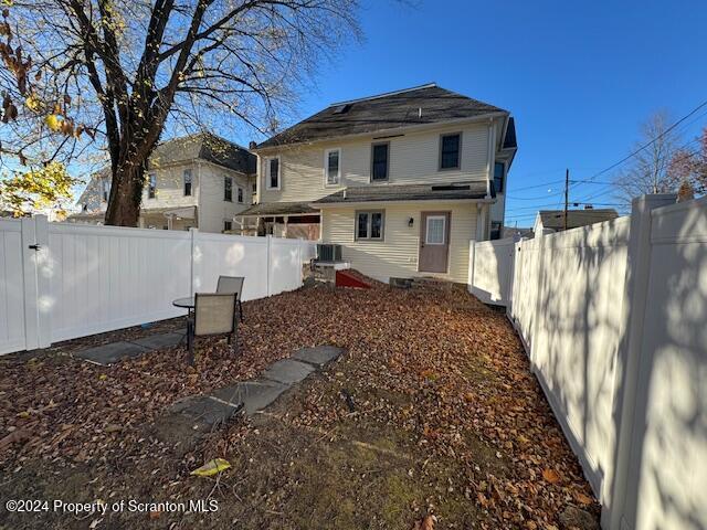 rear view of property with central AC