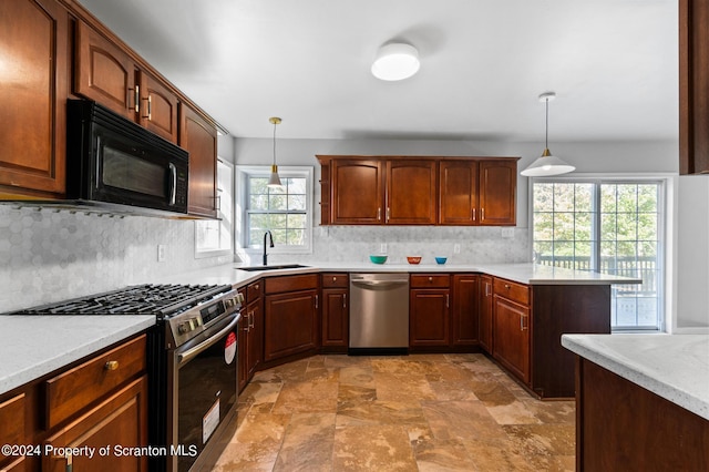 kitchen featuring decorative light fixtures, sink, stainless steel appliances, and tasteful backsplash