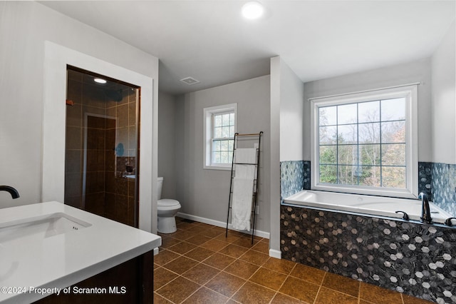 bathroom with tile patterned floors, tiled bath, vanity, and toilet