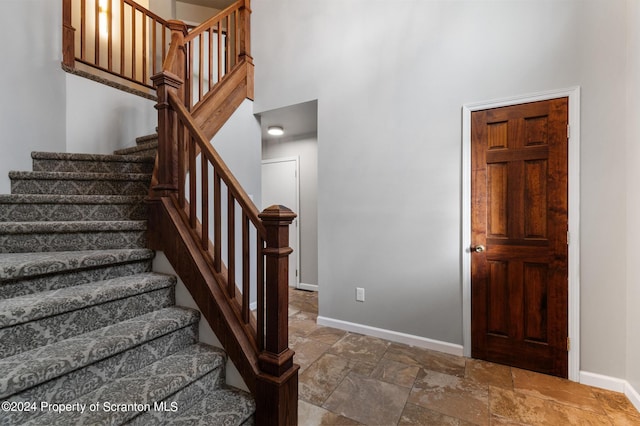 staircase featuring a high ceiling