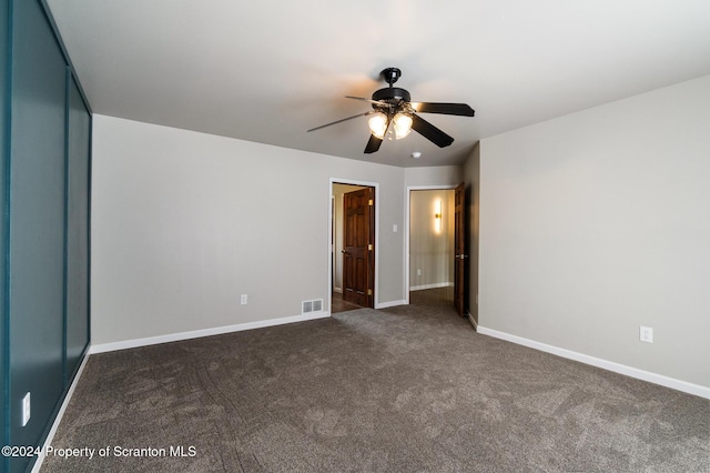 unfurnished bedroom featuring ceiling fan and dark colored carpet