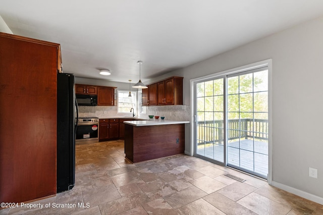 kitchen with pendant lighting, decorative backsplash, stainless steel range oven, and sink