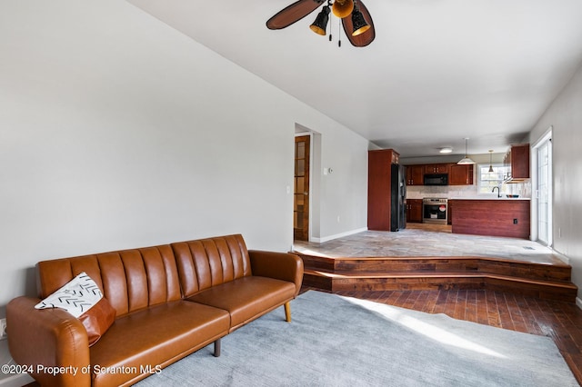 living room with ceiling fan, light wood-type flooring, and sink