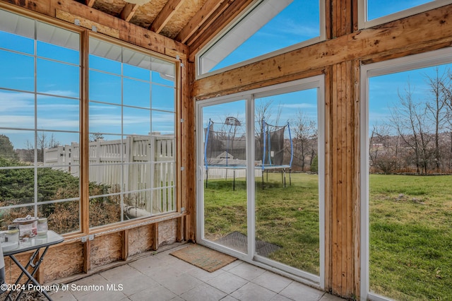 unfurnished sunroom featuring vaulted ceiling