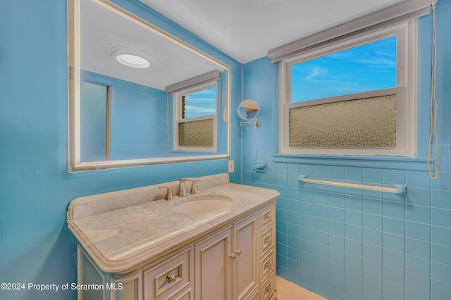 bathroom featuring vanity and tile walls