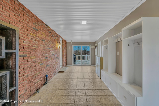 mudroom with brick wall