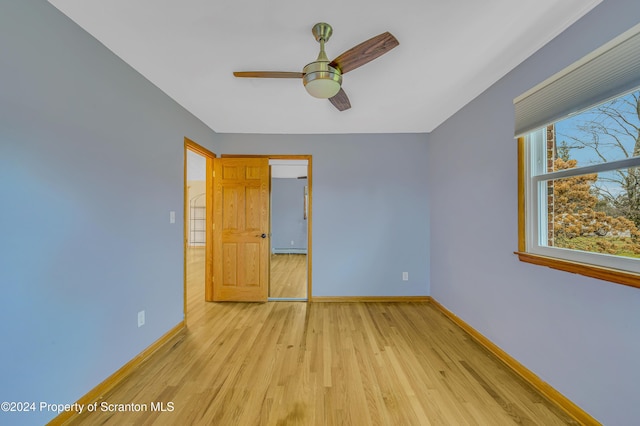 unfurnished bedroom featuring ceiling fan, a closet, light hardwood / wood-style floors, and a baseboard heating unit