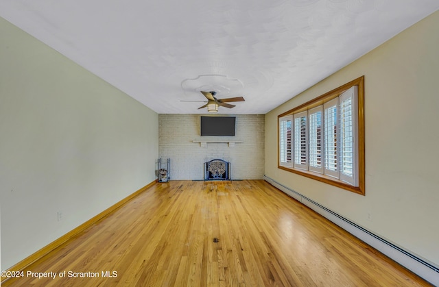 unfurnished living room featuring a brick fireplace, hardwood / wood-style flooring, ceiling fan, and a baseboard heating unit