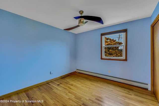 spare room with light wood-type flooring, a baseboard radiator, and ceiling fan