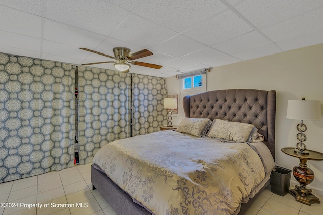 tiled bedroom with a paneled ceiling and ceiling fan