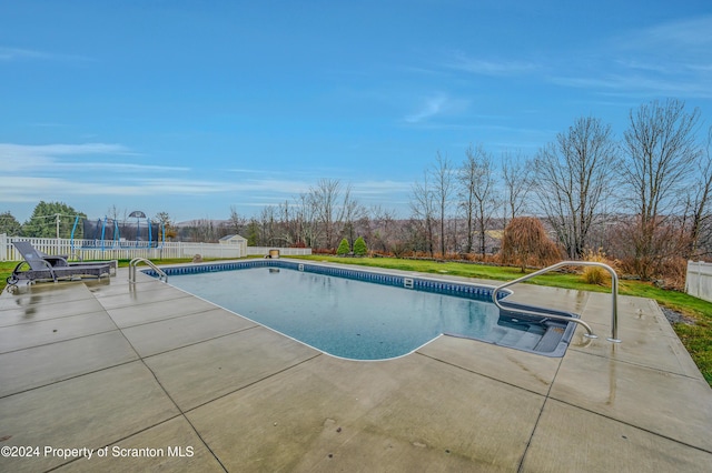 view of swimming pool featuring a patio and a trampoline