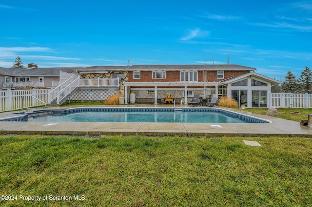 view of swimming pool with a yard and a deck