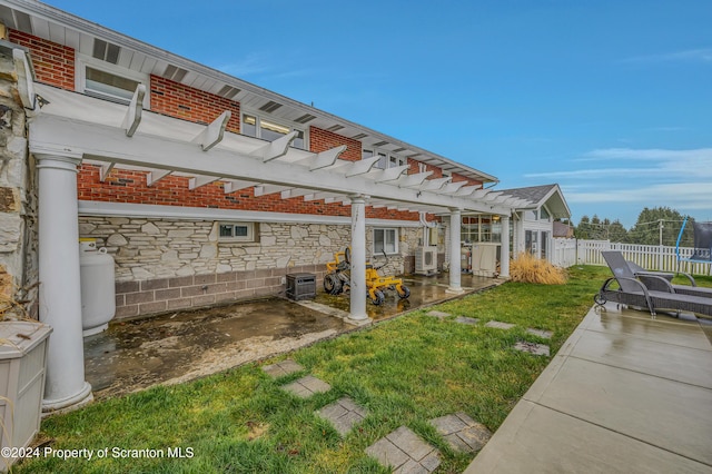 exterior space with ac unit, a trampoline, and a pergola