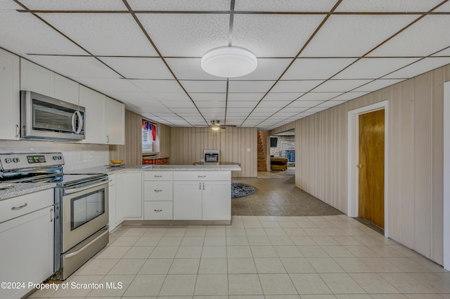 kitchen featuring kitchen peninsula, white cabinetry, a drop ceiling, and appliances with stainless steel finishes