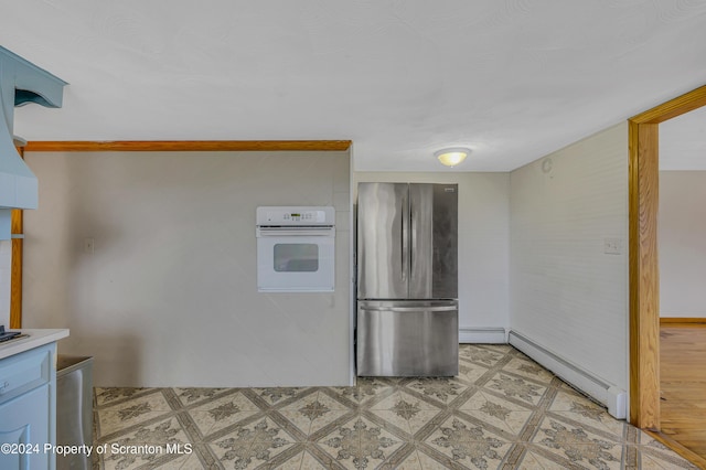 kitchen with white oven, stainless steel refrigerator, and baseboard heating