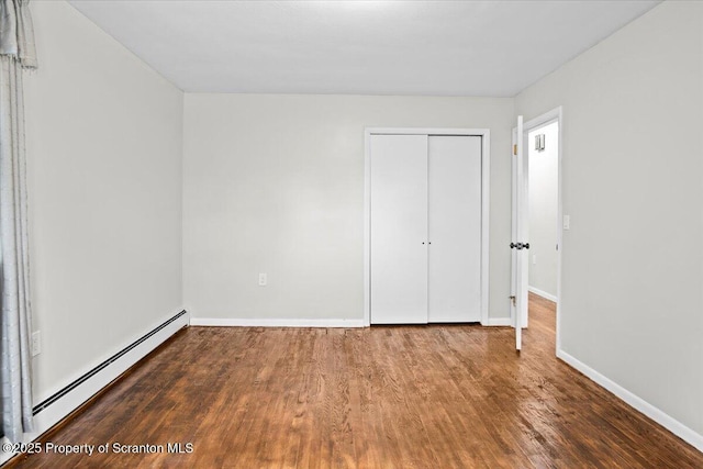 206 Florence Dr, Clarks Summit, PA 18411 - unfurnished bedroom with baseboard heating, wood finished floors, and a closet