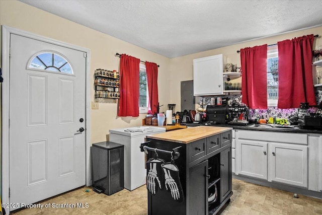 kitchen with white cabinetry, sink, a healthy amount of sunlight, and a kitchen island