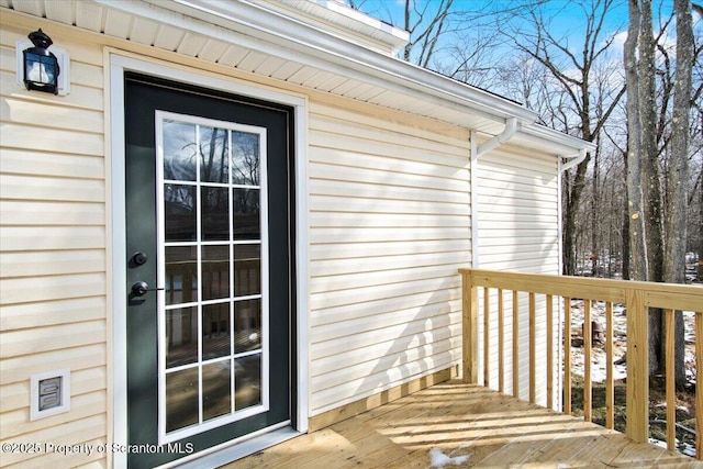 view of exterior entry featuring a wooden deck