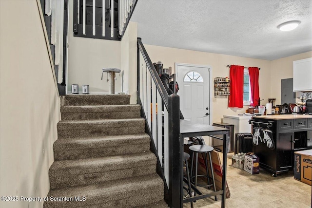 staircase with a textured ceiling