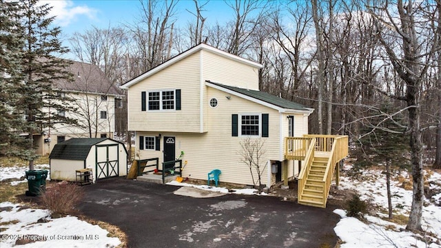 view of front of house featuring a storage shed and a wooden deck