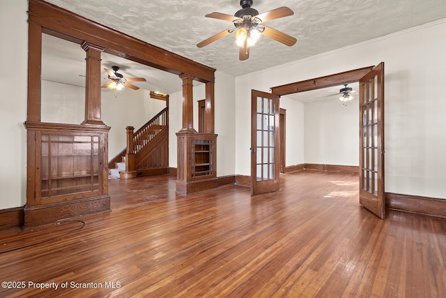 818 Cherry St, Scranton, PA 18505 - unfurnished living room featuring french doors, hardwood / wood-style flooring, ceiling fan, stairs, and ornate columns