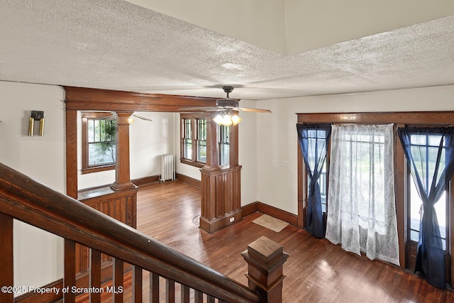 818 Cherry St, Scranton, PA 18505 - foyer with ornate columns, radiator, a textured ceiling, wood finished floors, and a ceiling fan