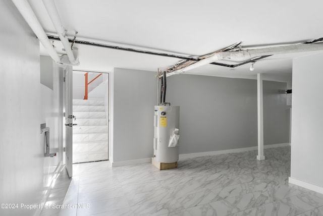 basement with marble finish floor, baseboards, and electric water heater