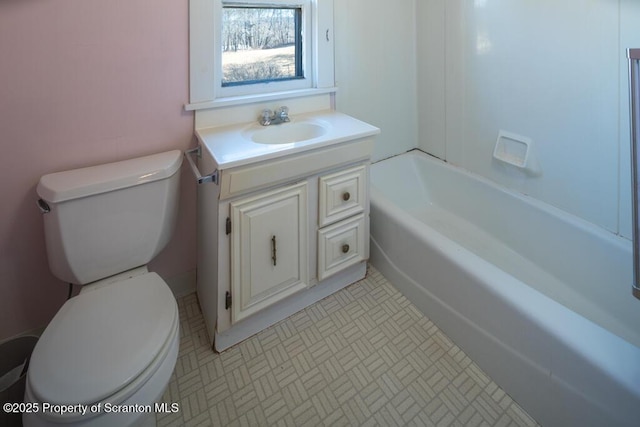 bathroom featuring toilet, vanity, and a tub