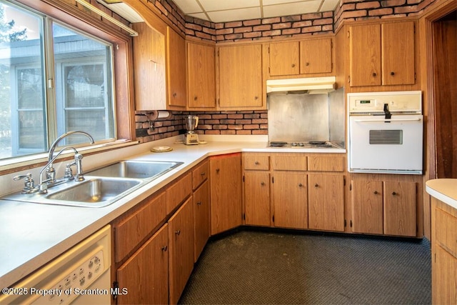 kitchen featuring sink, white appliances, and a paneled ceiling